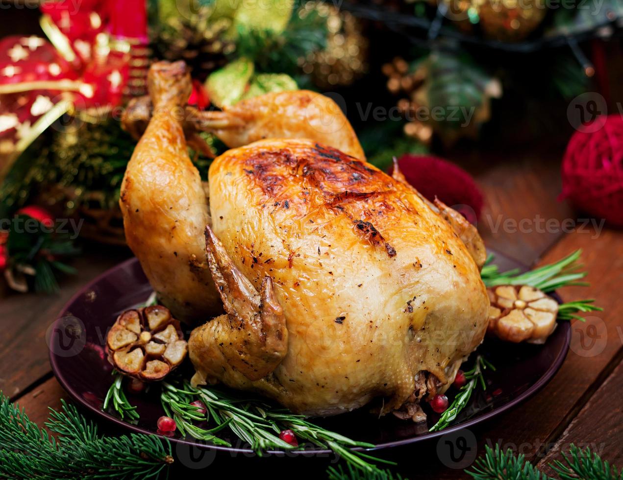 Baked turkey or chicken. The Christmas table is served with a turkey, decorated with bright tinsel and candles. Fried chicken, table. Christmas dinner. photo