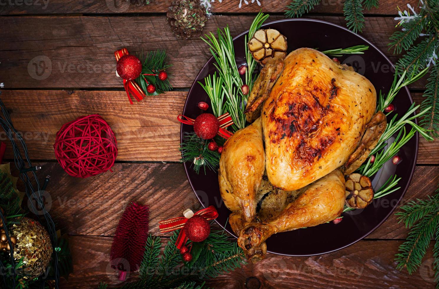 Baked turkey or chicken. The Christmas table is served with a turkey, decorated with bright tinsel and candles. Fried chicken, table. Christmas dinner. Flat lay. Top view photo