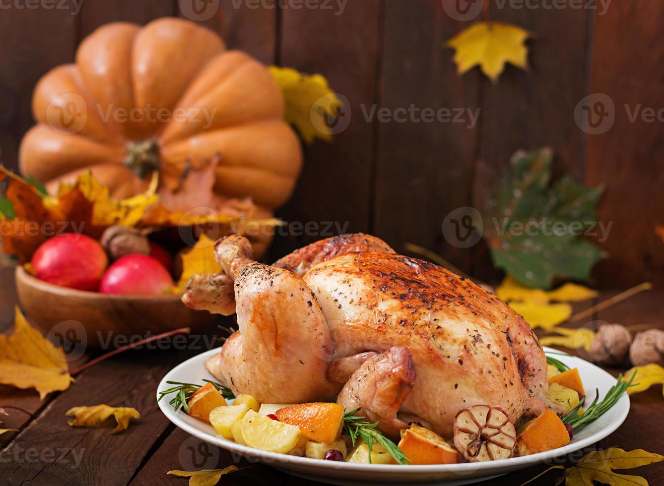 Roasted turkey garnished with cranberries on a rustic style table decorated with pumpkins, orange, apples and autumn leaf. Thanksgiving Day. photo