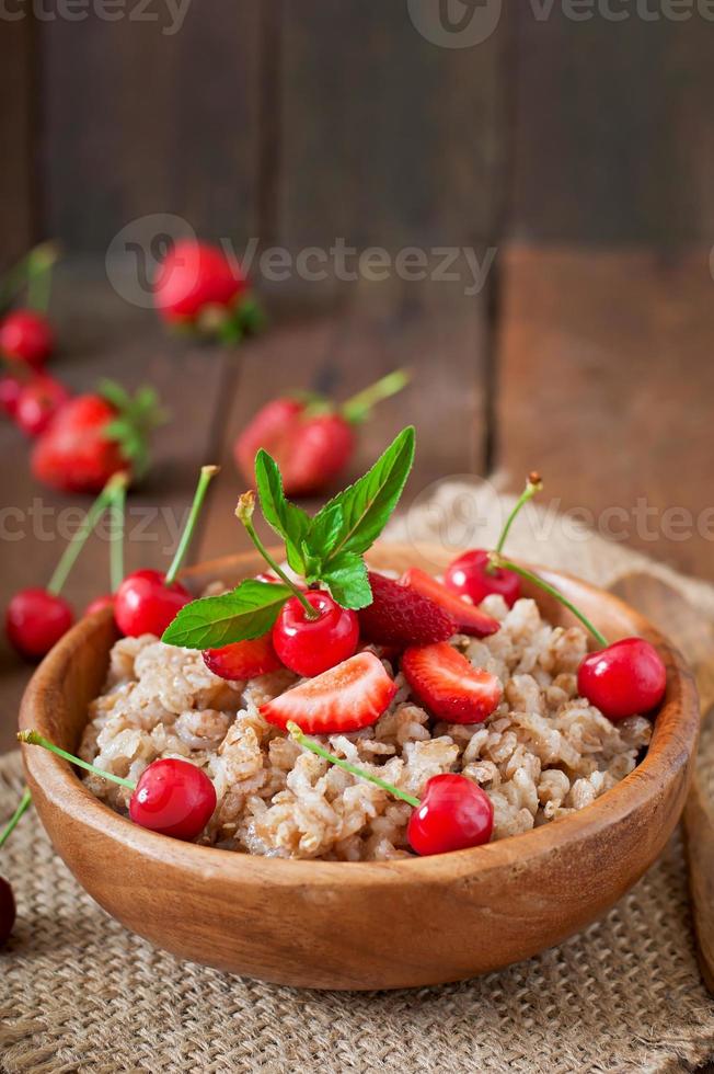 Oatmeal porridge with berries in a white bowl photo