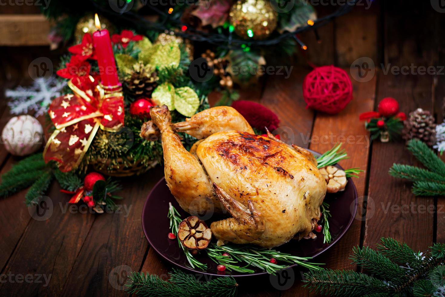 Baked turkey or chicken. The Christmas table is served with a turkey, decorated with bright tinsel and candles. Fried chicken, table. Christmas dinner. photo