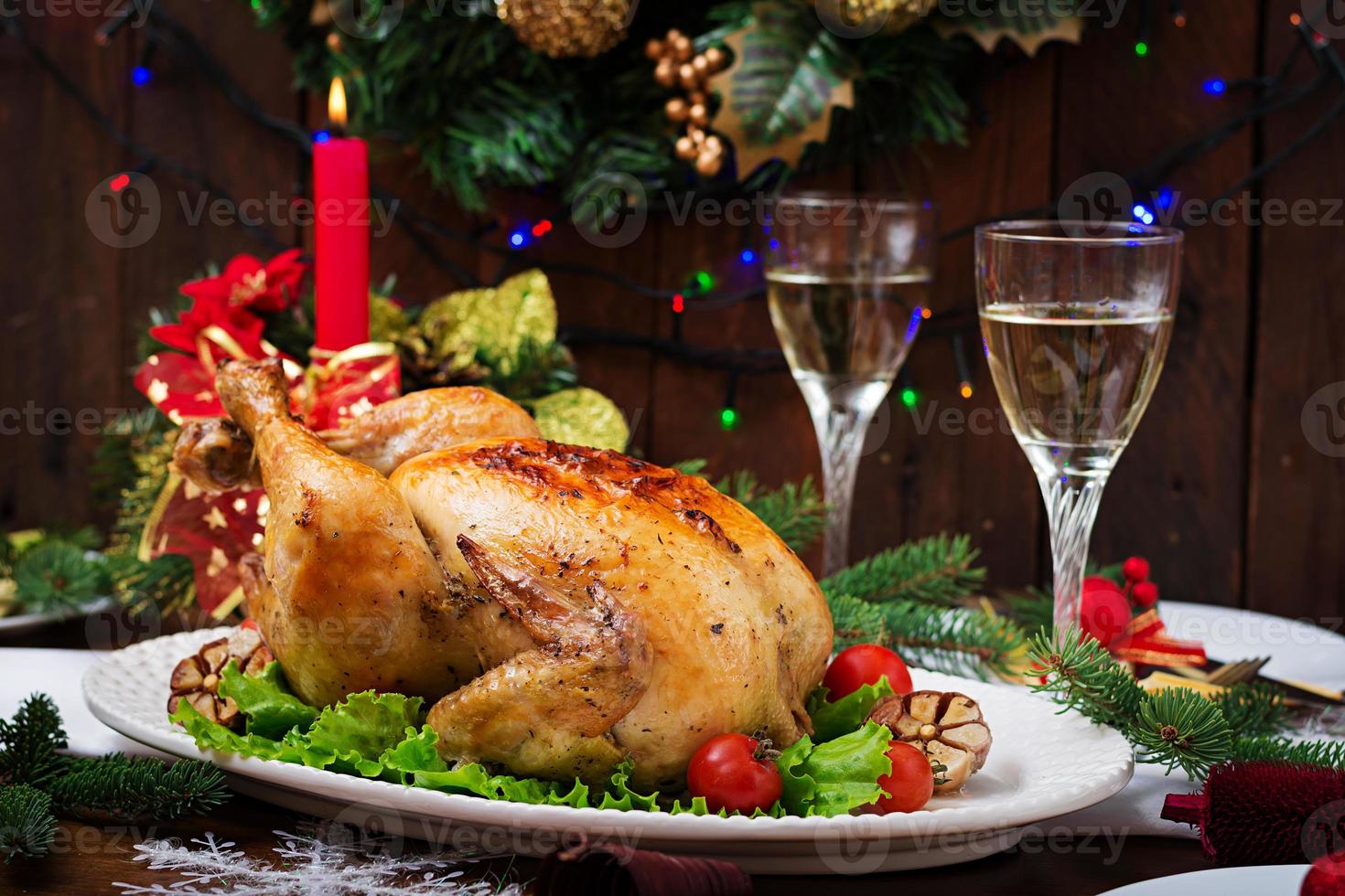 Baked turkey or chicken. The Christmas table is served with a turkey, decorated with bright tinsel and candles. Fried chicken, table. Christmas dinner. photo