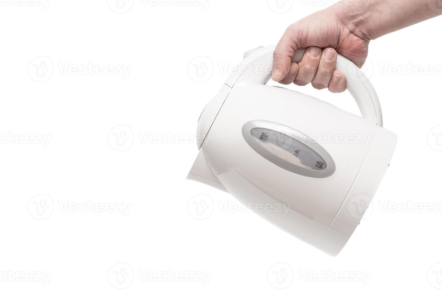 Hand holding a white electric kettle. Close up. Isolated on a white background. photo