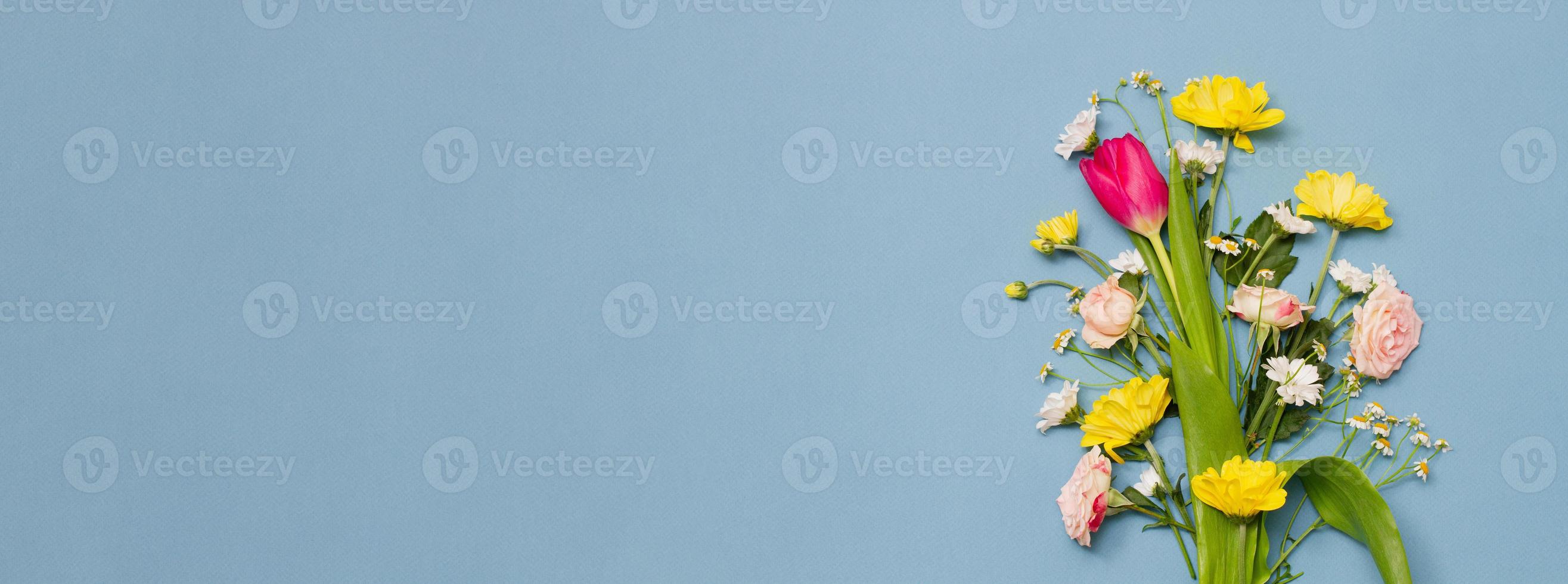 large varied spring bouquet on pastel blue background. photo