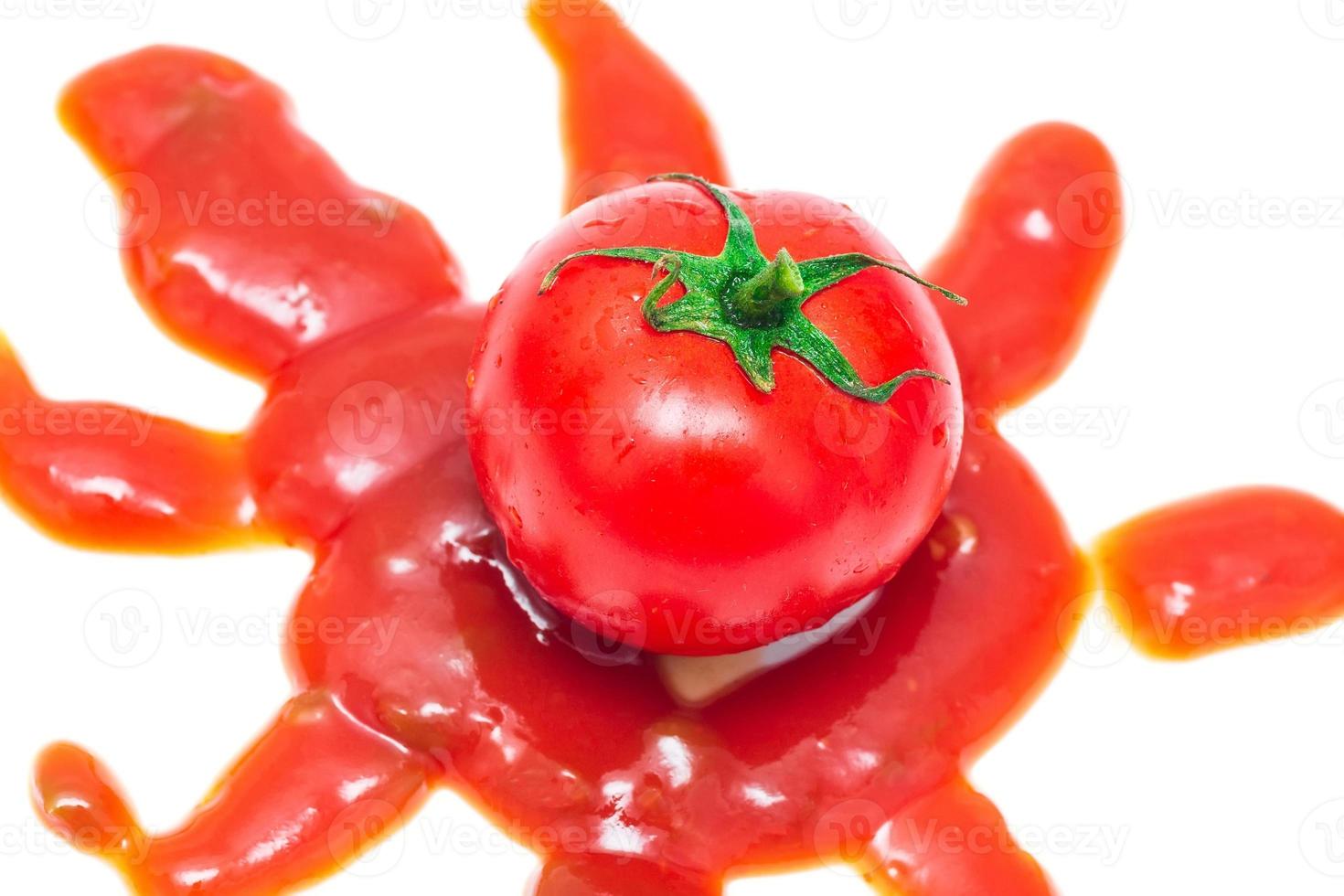 Tomate salpicado con ketchup aislado sobre fondo blanco. foto