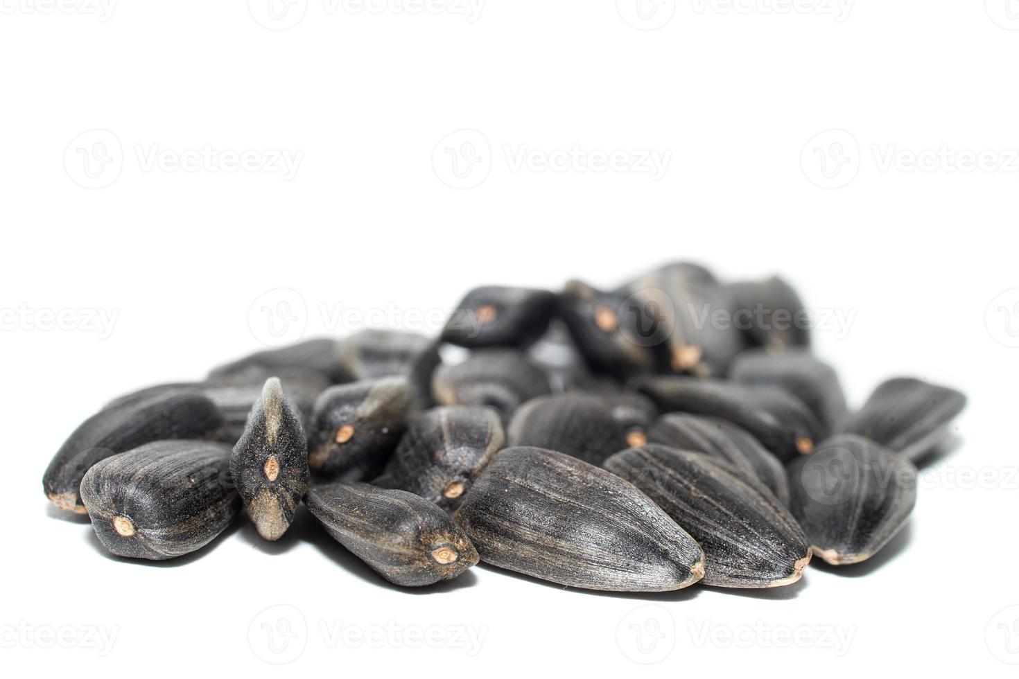 Close-up of delicious sunflower black seeds, isolated on white background photo