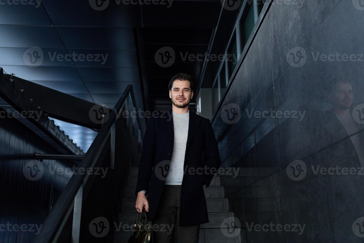 un hombre de negocios serio y fuerte desciende las escaleras del centro de negocios foto