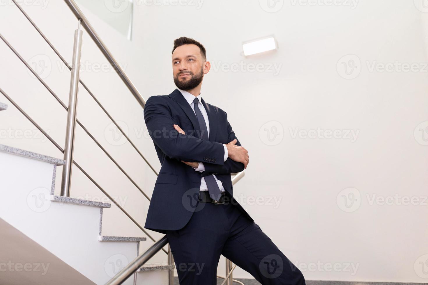 retrato de negocios de un hombre con traje de oficina en el rellano. concepto de crecimiento profesional foto
