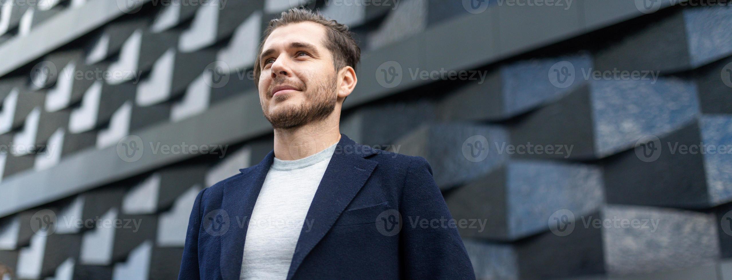 close-up portrait of a serious businessman against the background of the texture wall of the building photo