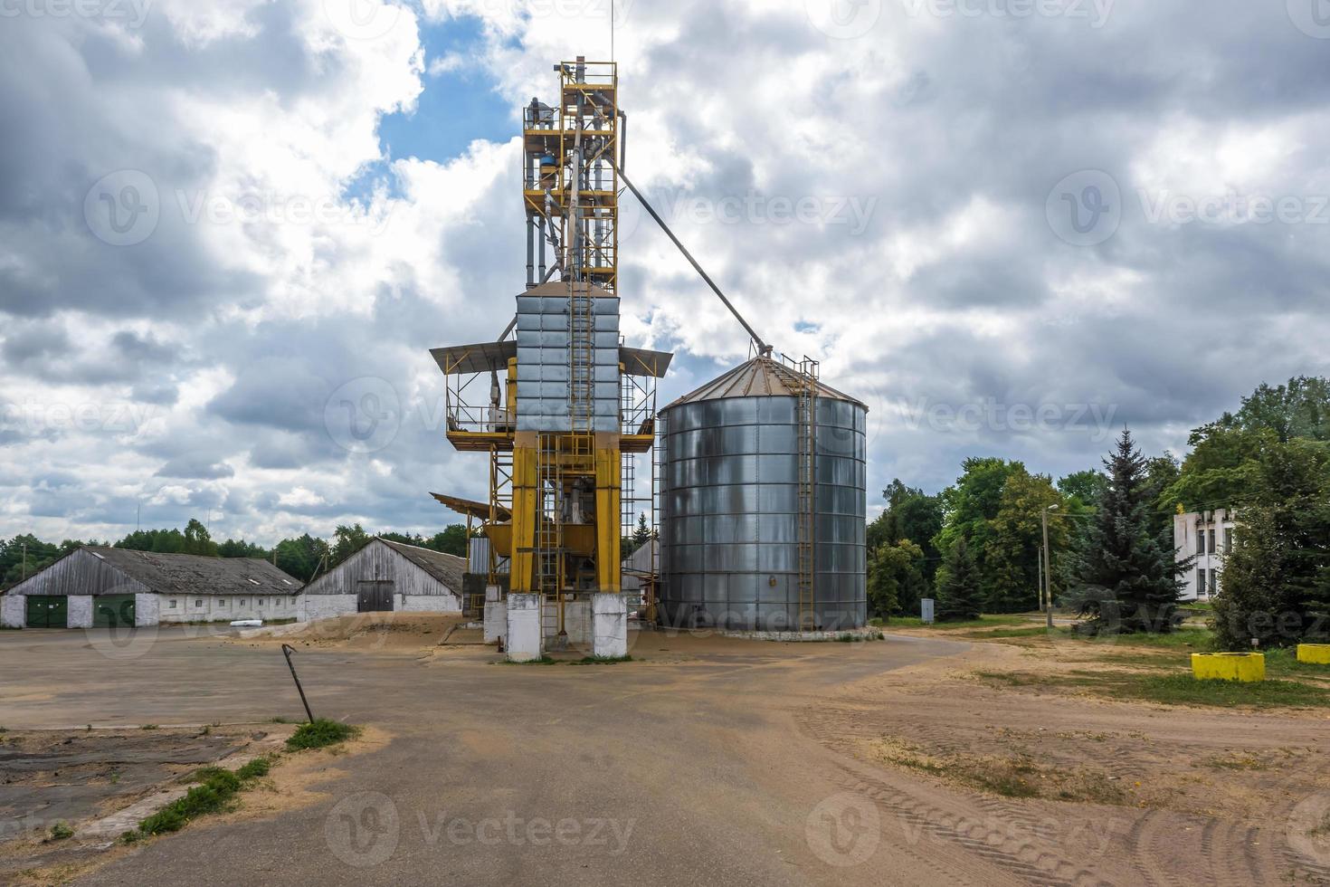 row of agro silos granary elevator with seeds cleaning line on agro-processing manufacturing plant for processing drying cleaning and storage of agricultural products photo