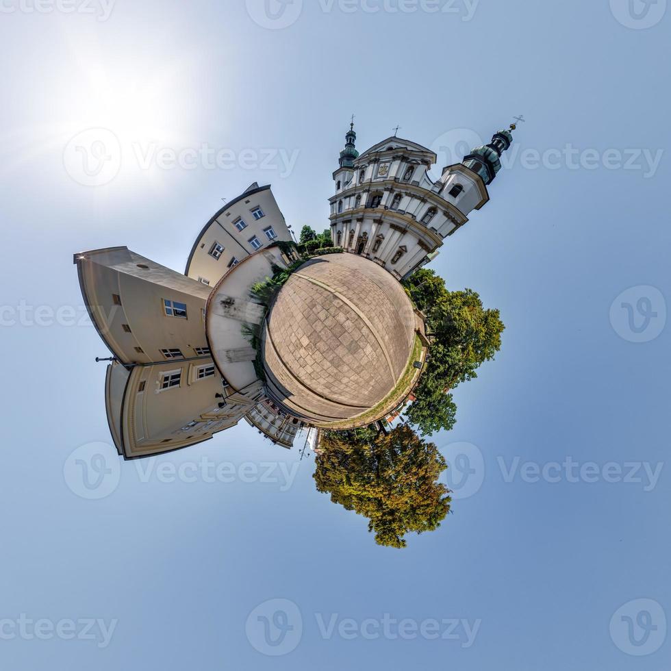 Little planet and spherical aerial 360 panorama view on street ancient medieval city with church and historic buildings photo