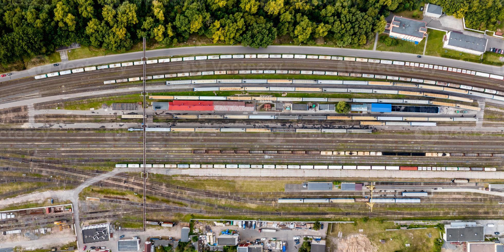 panoramic aerial view over long railway freight trains with lots of wagons stand on parking photo
