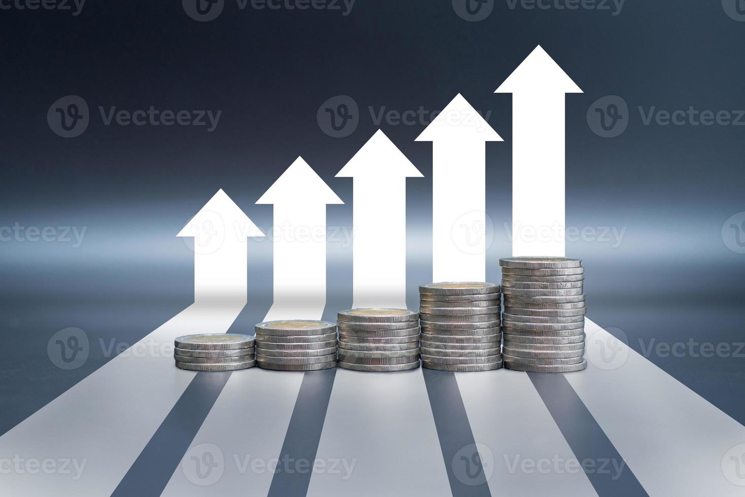 Stack of coins on black table with arrow graph growth up photo