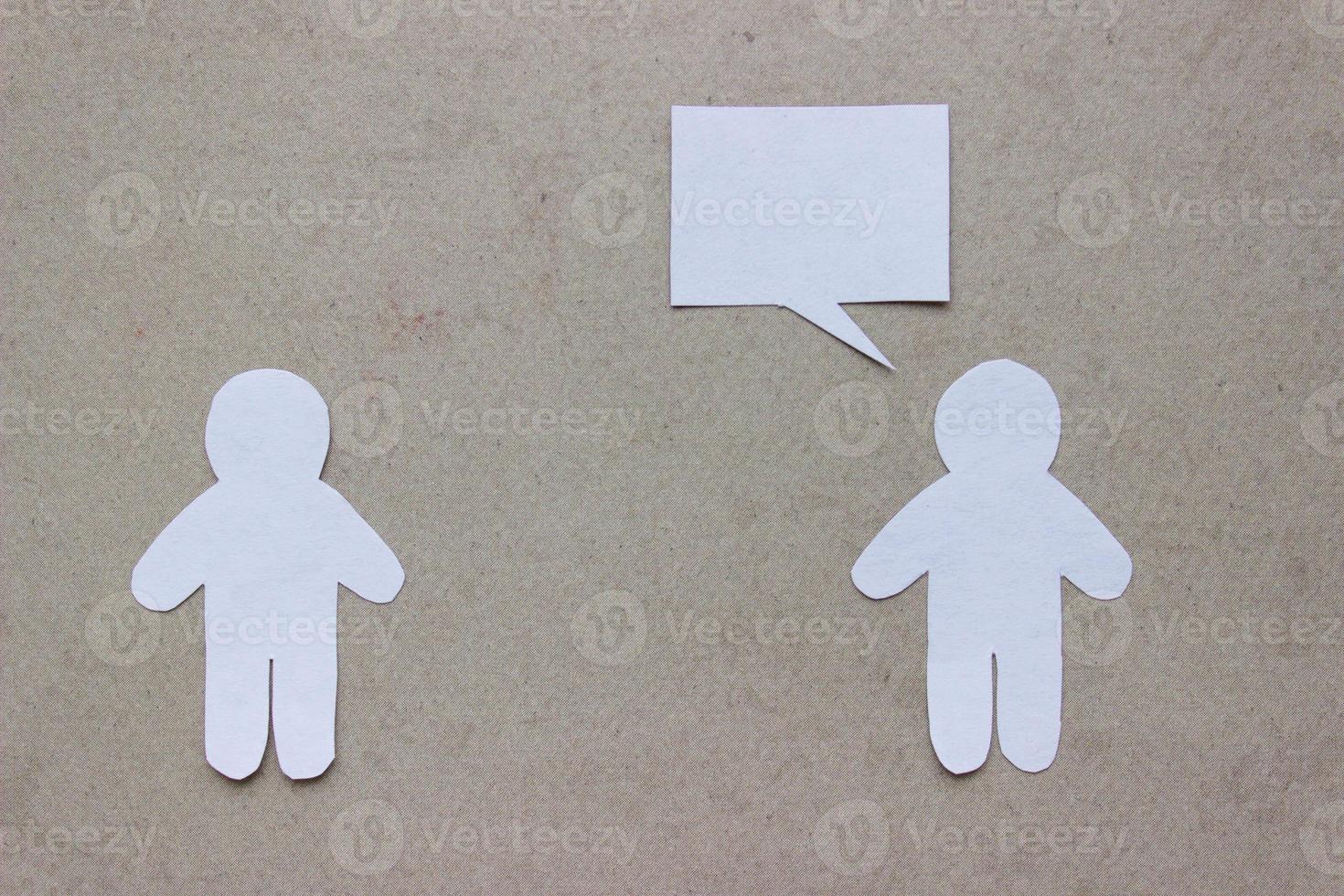 siluetas de personas cortadas de papel blanco sobre un fondo beige. las personas se paran una frente a la otra, una de ellas está hablando con burbujas de discurso. comunicación, liderazgo, colaboración, trabajo en equipo, etc. foto