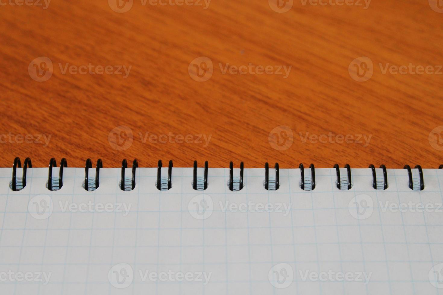 Notepad on a wooden table with copy space. View from above. Design blank. photo