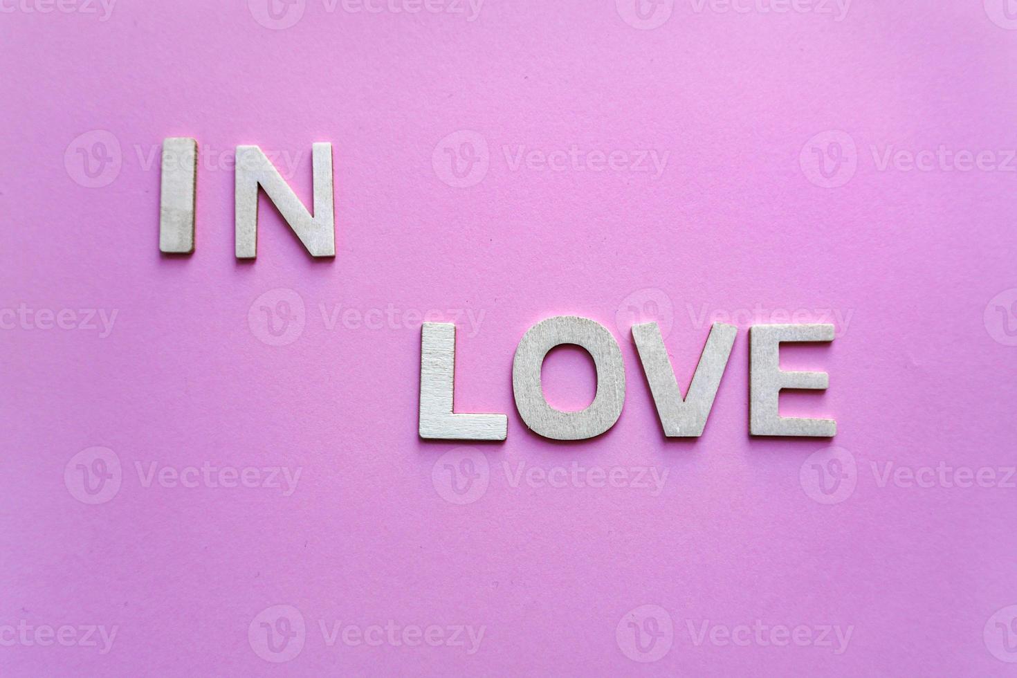 palabra de amor con letras de madera en el fondo rosa, día de san valentín foto