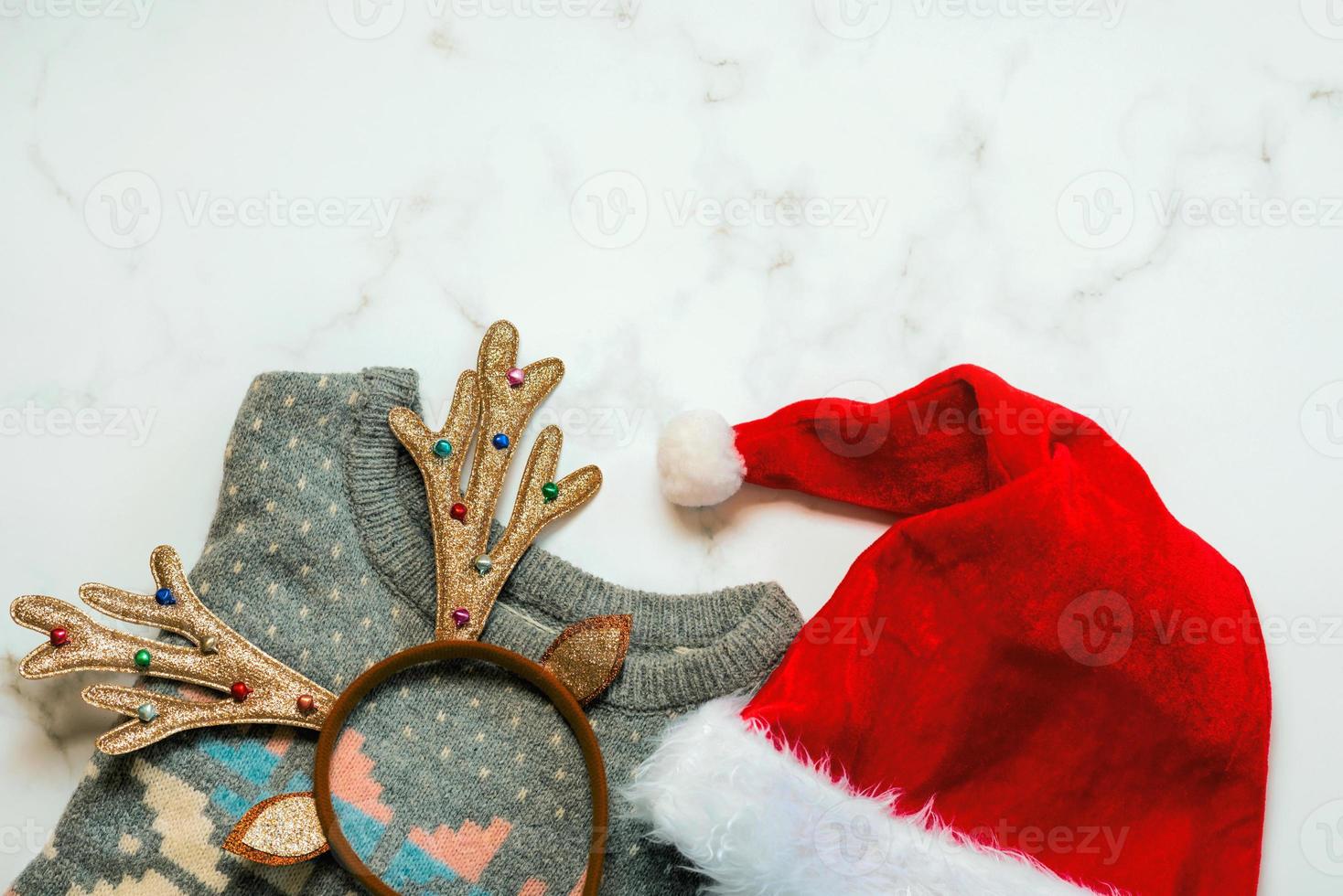 Feliz Navidad. vista superior del suéter navideño con cuernos de venado de juguete navideño brillante y sombrero de santa foto