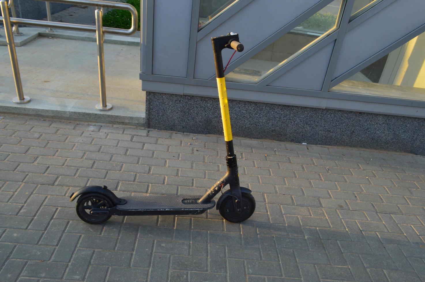 bright yellow electric scooter on small wheels for people to ride. lease of ground pedestrian transport. ease of movement. green accessible environment in the city, caring for the environment photo