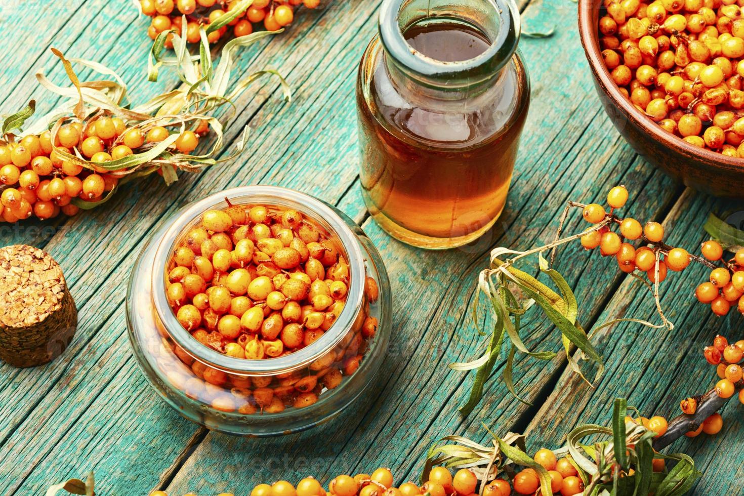 Sea buckthorn in glass bottle photo