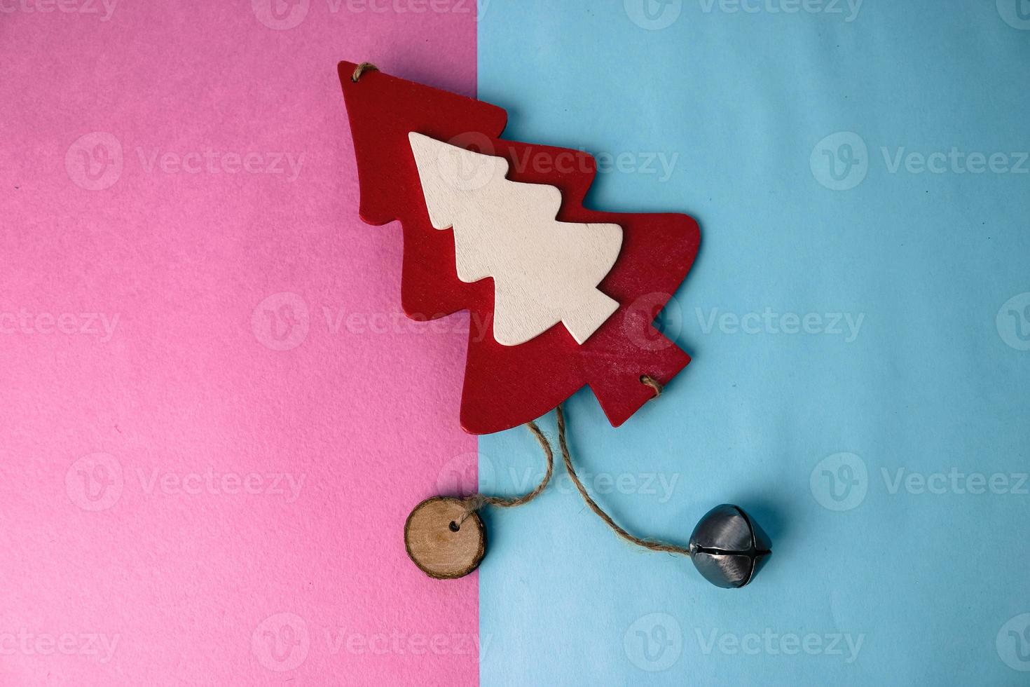 Festive New Year's Christmas beautiful bright multi-colored joyful blue and pink background with a small toy wooden red and white cute Christmas tree. Flat lay. Top view. Holiday decorations photo