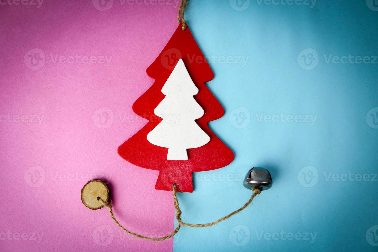 Festive New Year's Christmas beautiful bright multi-colored joyful blue and pink background with a small toy wooden red and white cute Christmas tree. Flat lay. Top view. Holiday decorations photo