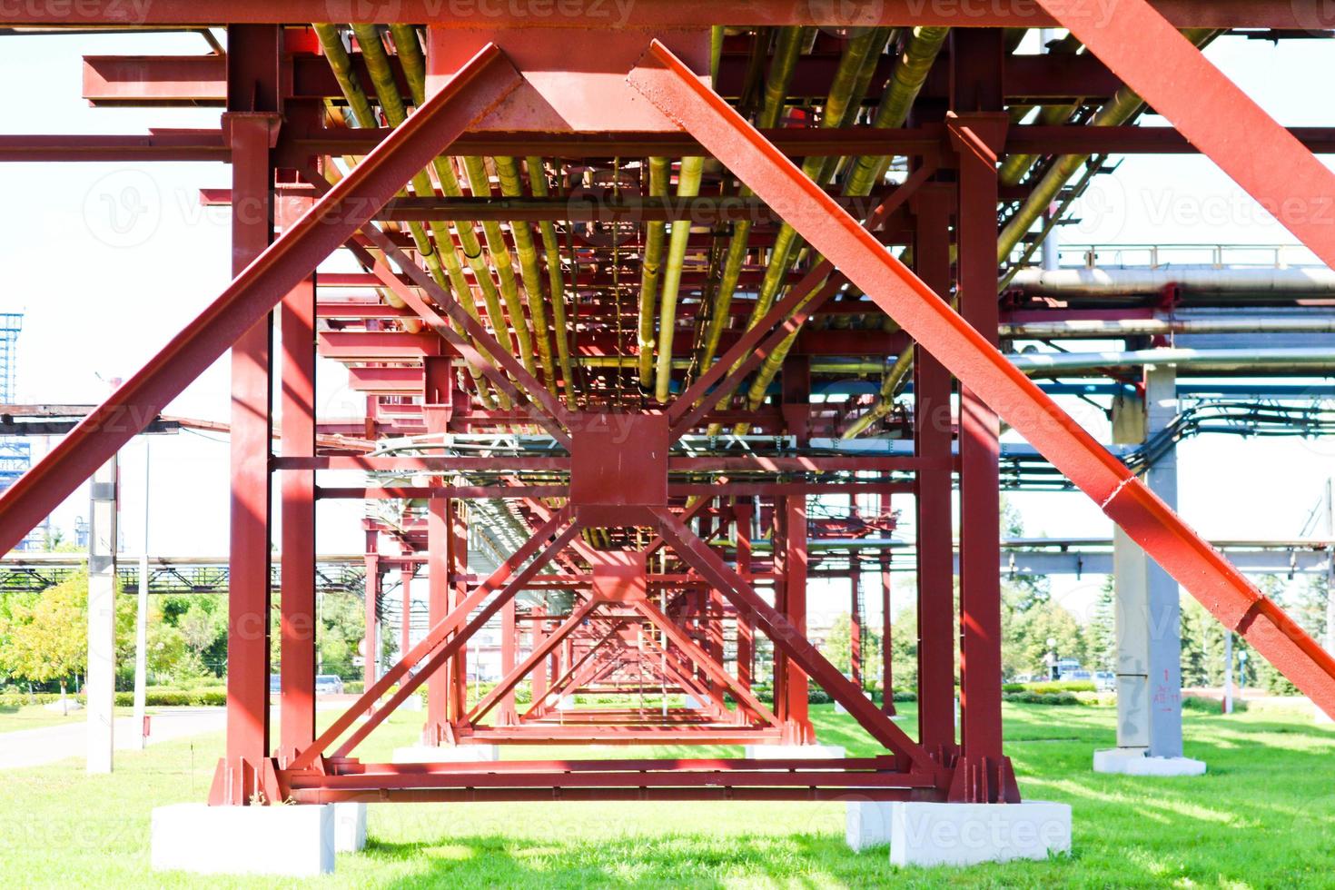 Red metal structures, wheel supports for pipes, pipeline trestle from large beams, piles and stiffeners at the oil refinery, petrochemical, chemical industrial plant, the enterprise photo