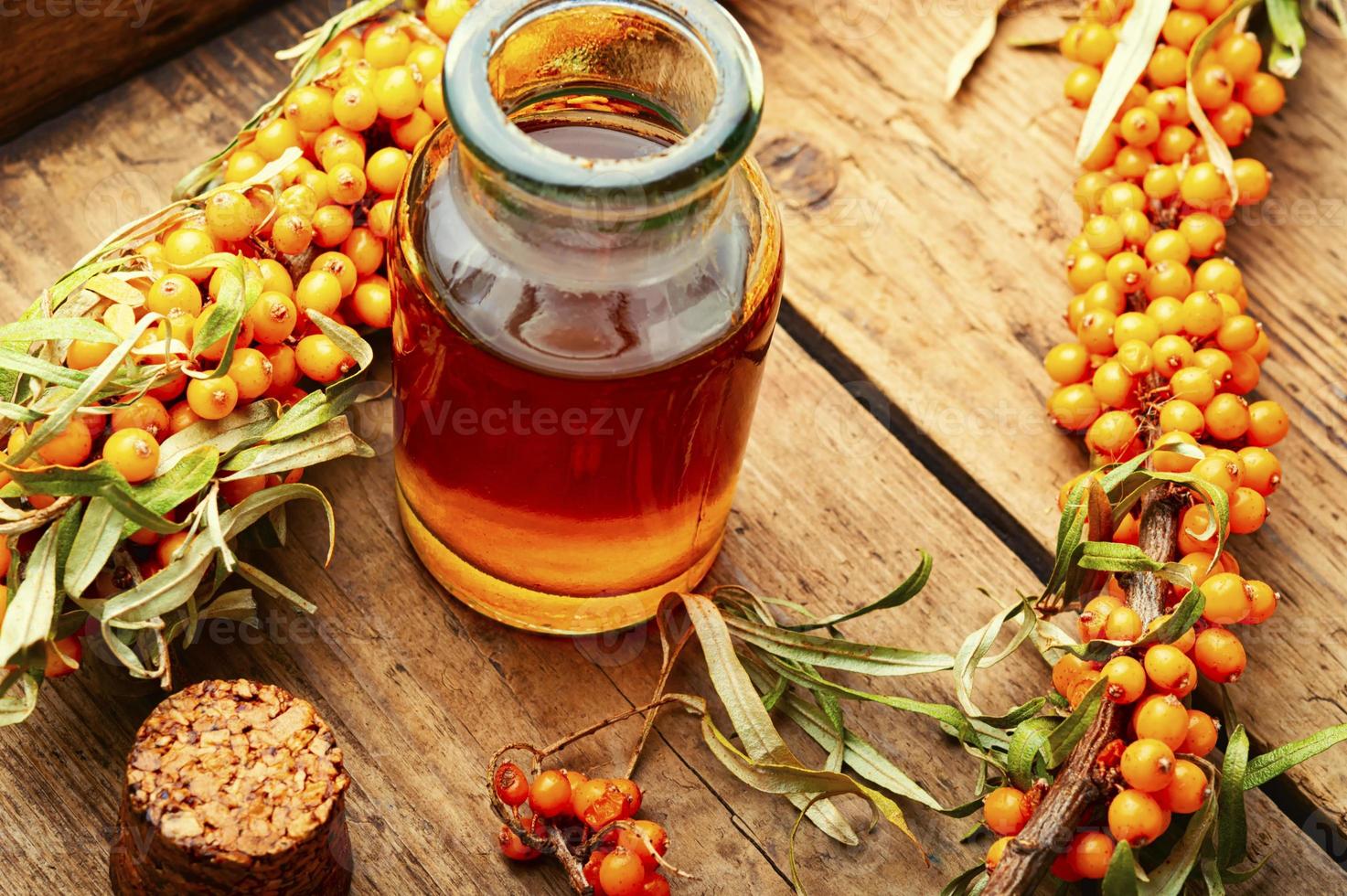 Sea buckthorn in glass bottle photo