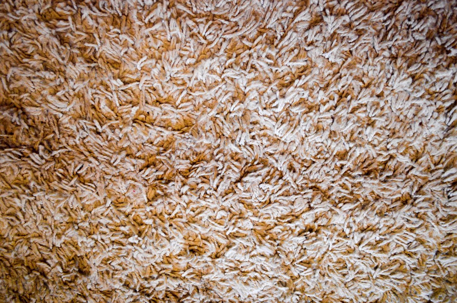 Texture of fluffy, fleecy beige carpet, background photo