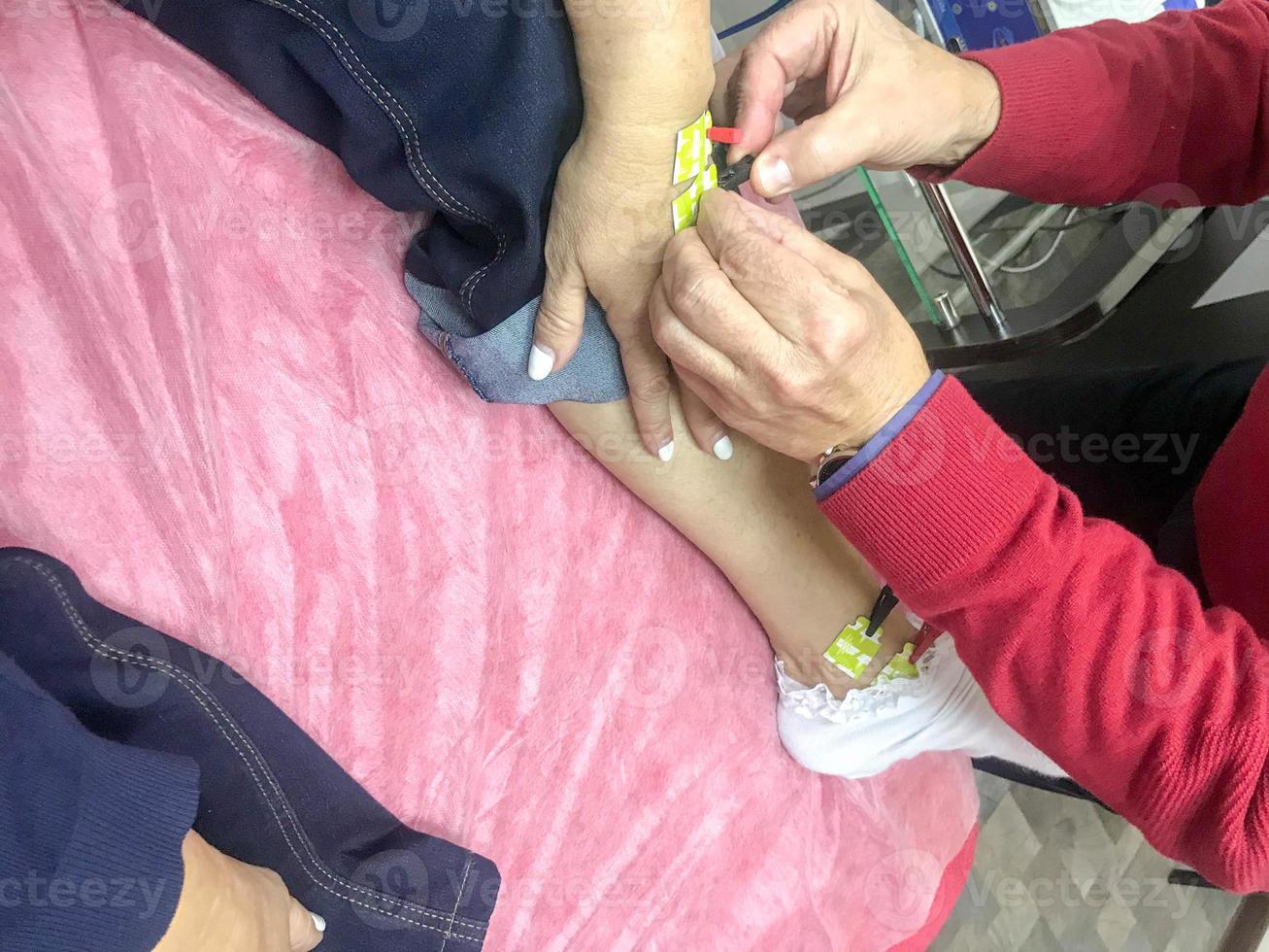 A person is given a bioimpedance medical analysis to diagnose body composition. Sensors are connected to the arm for medical analysis and patient care photo