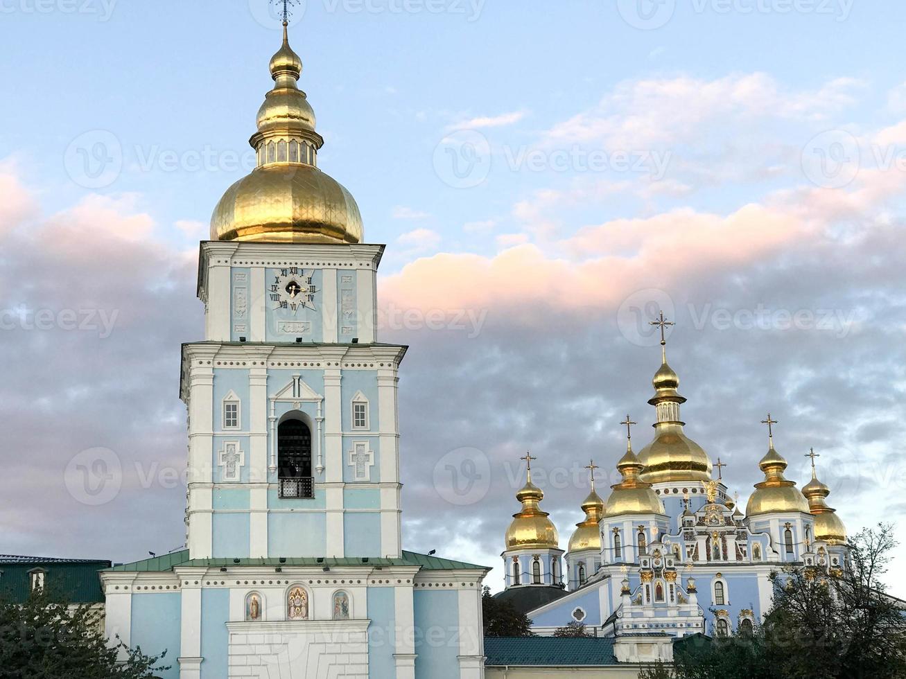Many golden domes of churches against the background of beautiful pink clouds. photo