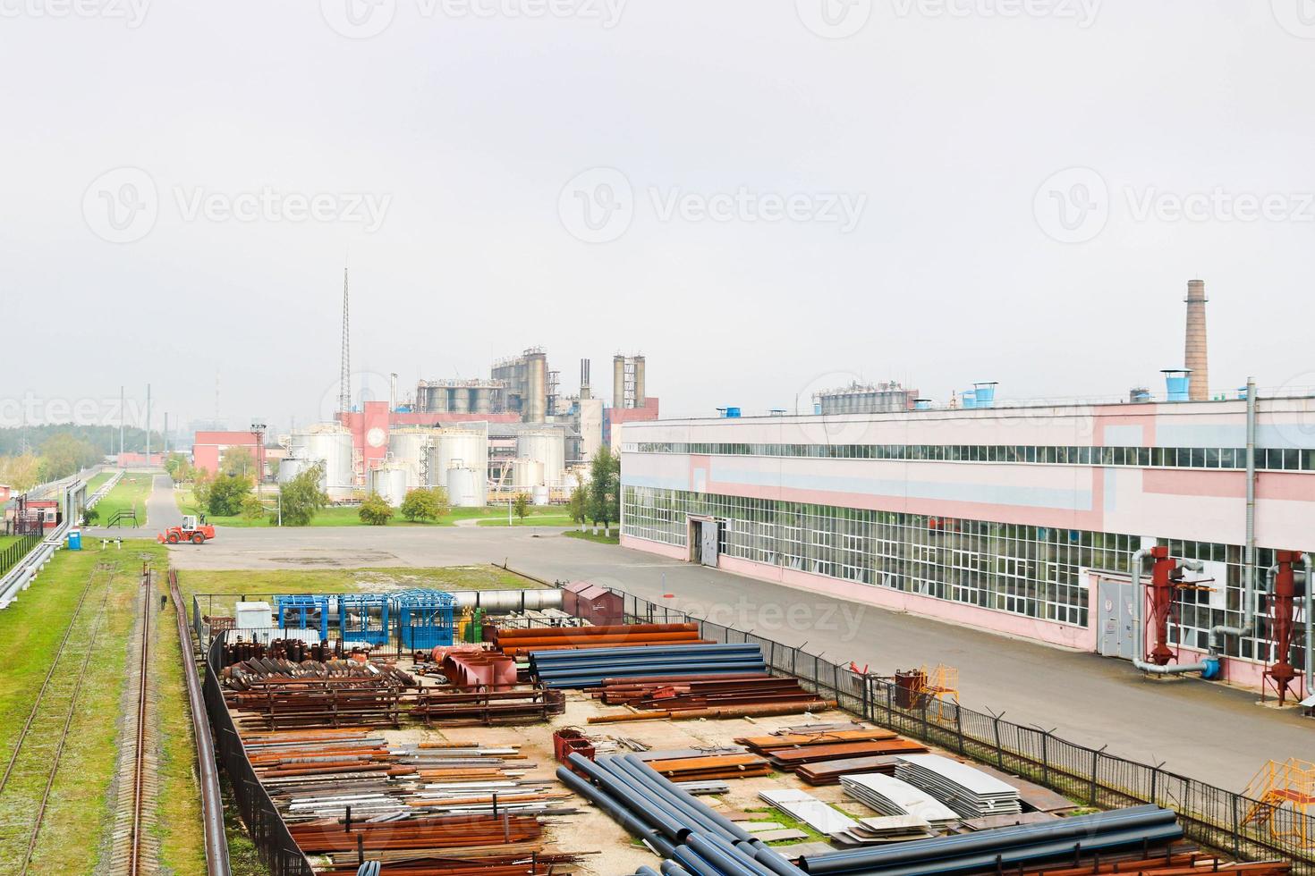 paisaje industrial. vista panorámica de las tuberías tecnológicas. tuberías oxidadas, rubíes azules, comunicaciones de producción. reparar edificios en producción. contra el fondo de un cielo brumoso foto