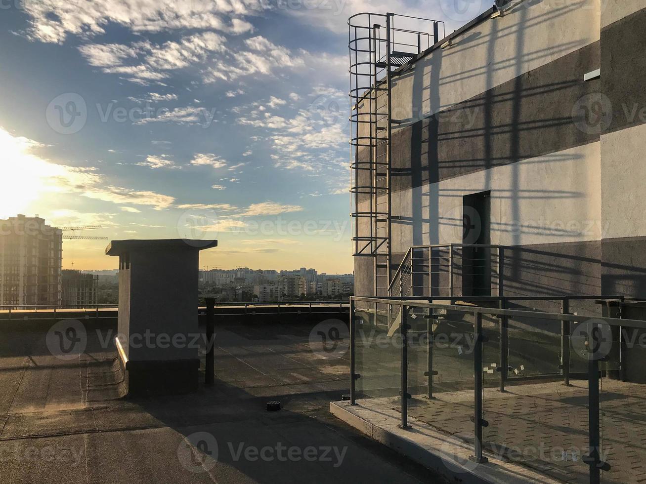 veranda on the roof of the house. metal structures for fencing off other people. own barbecue area on the roof. next to the house there is a staircase for access to the roof of a neighbor photo