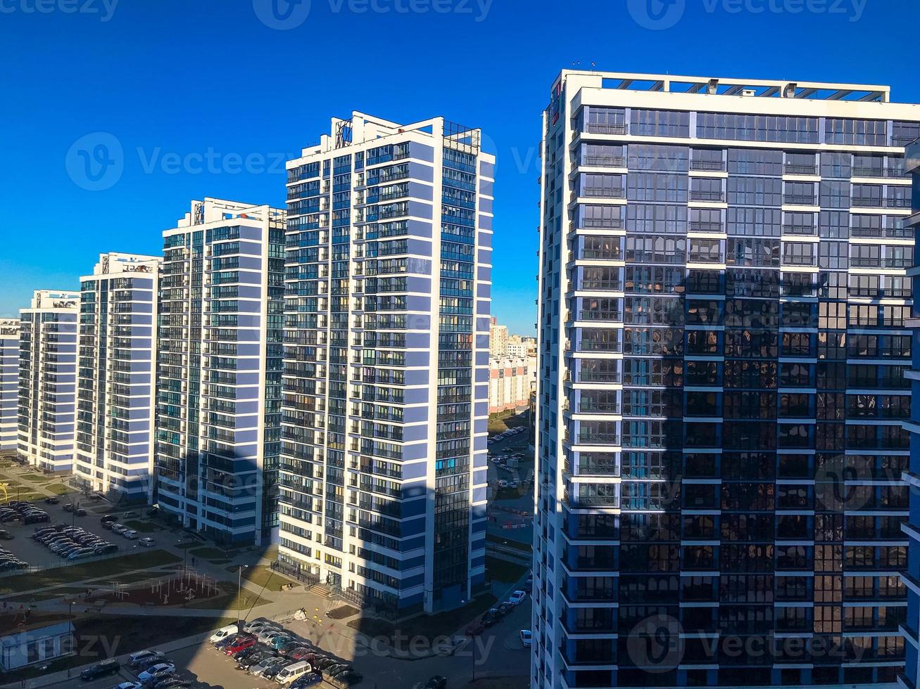 tall bright, blue and white, glass houses, a new area of the city. buildings on 25 floors in the city center from a bird's eye view. lawn for recreation and outdoor games. new buildings in the capital photo