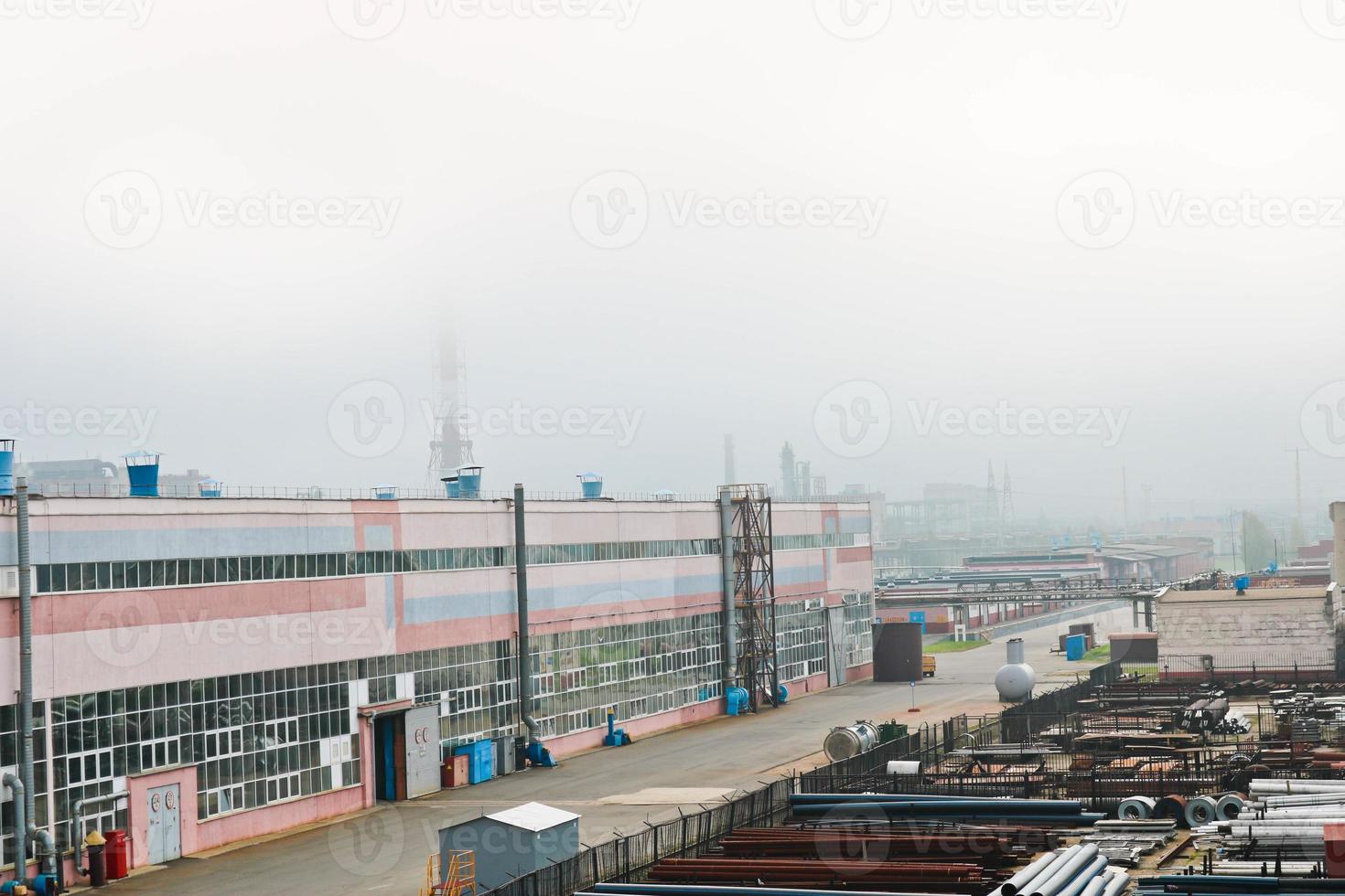 Industrial landscape. Panoramic view of the technological pipes. Rusty pipes, blue rubies, production communications. Repair buildings in production. Against the background of a misty sky photo