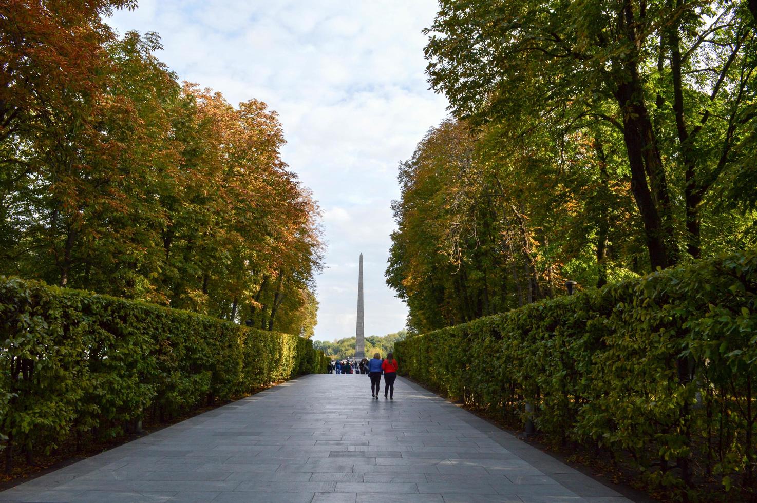 People walk along the green avenue of bushes and trees. Kiev. Ukraine. photo