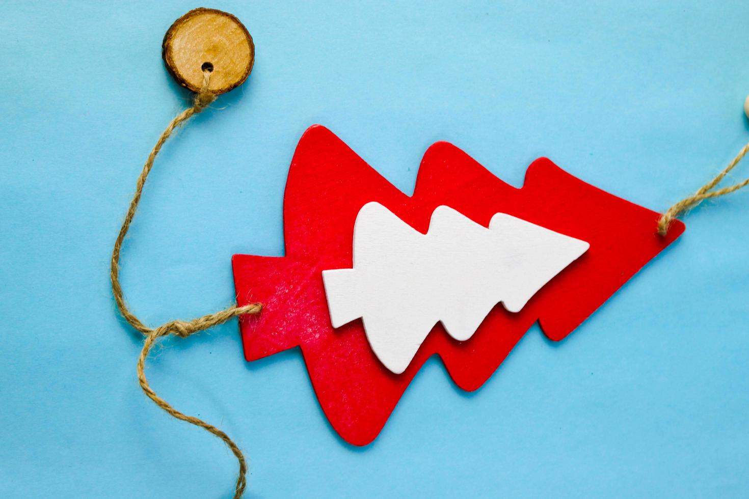 Festive New Year Christmas winter happy light blue beautiful joyful background with a small toy wooden homemade cute Christmas tree. Flat lay. Top view. Holiday decorations photo