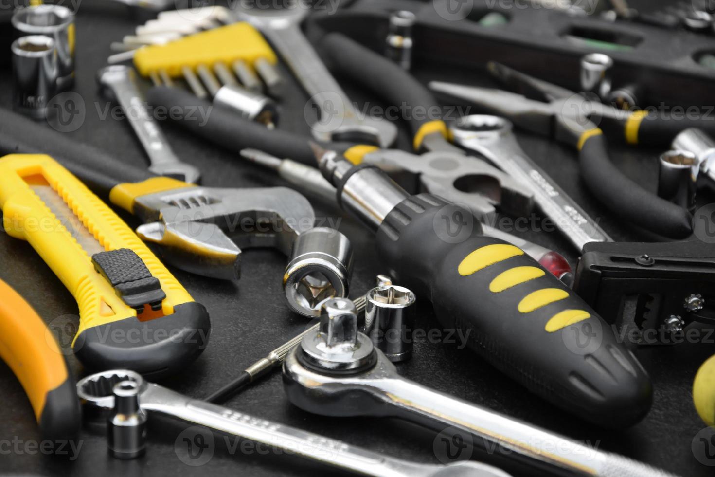 Handyman tool kit on black wooden table. Many wrenches and screwdrivers, pilers and other tools for any types of repair or construction works. Repairman tools photo