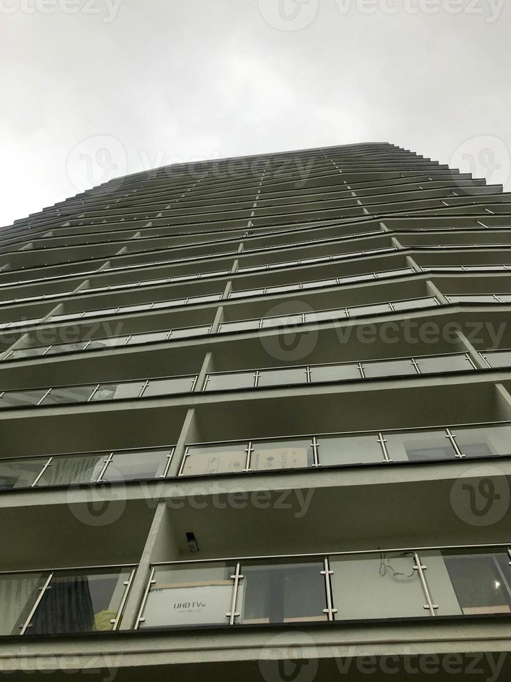 a beautiful tall white residential building with unusual architecture. the house has terraces for walking in the summer and spending time in the fresh air. against the background of the dark sky photo