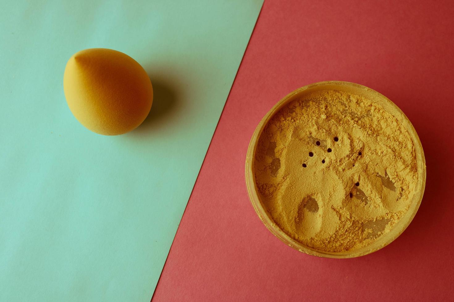 Beauty box, set of female cosmetics, crumbly matte mineral powder and blush with a beauty blender for makeup on a blue pink and purple background. Flat lay. Top view photo