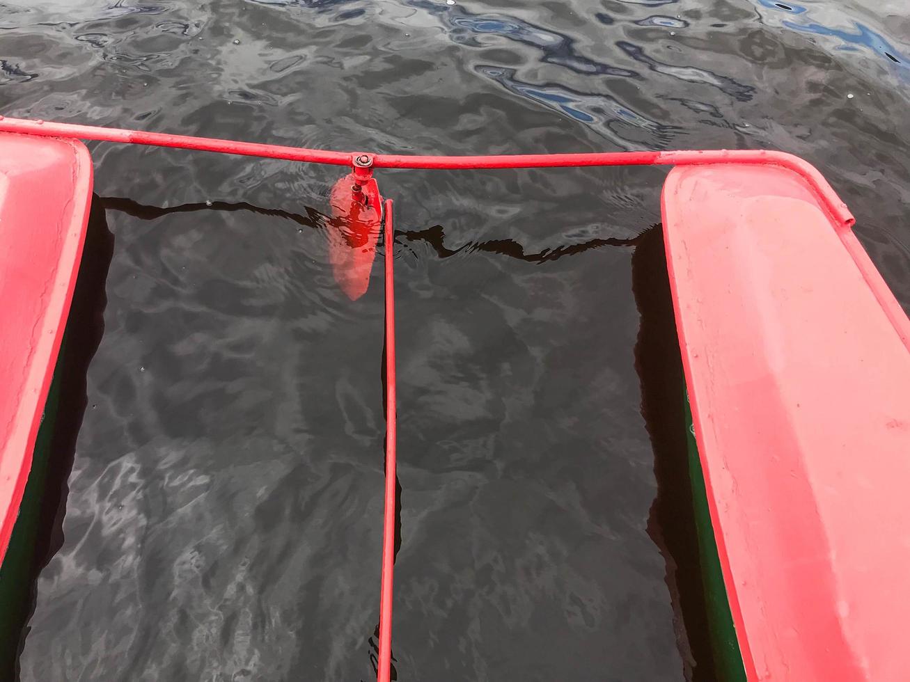 Iron metal steering wheel in a red boat catamaran in the water photo