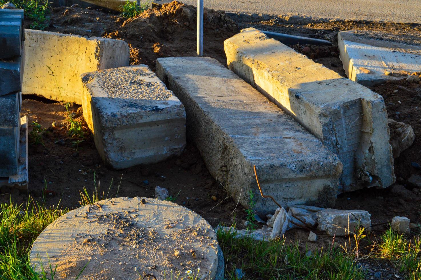 concrete blocks lie on the ground. construction of a plant, chemical production. next to a construction hatch made of concrete. creating a drain for groundwater. ensuring the safety of people photo