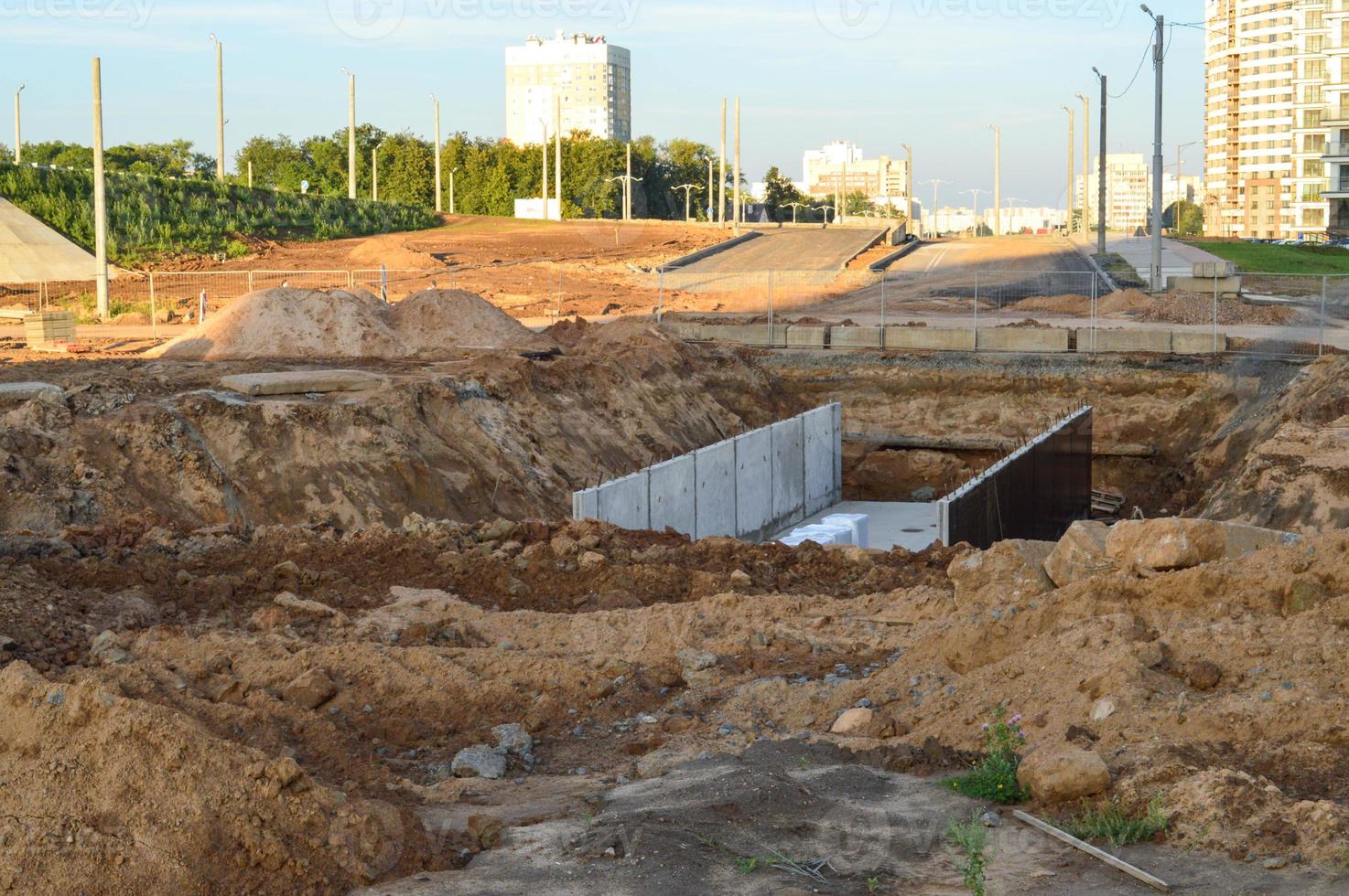 a deep hole with a metal frame has been dug in the ground. production of intra-land communications. laying pipes and creating a sewage system. laying of a new area, communications for residents photo