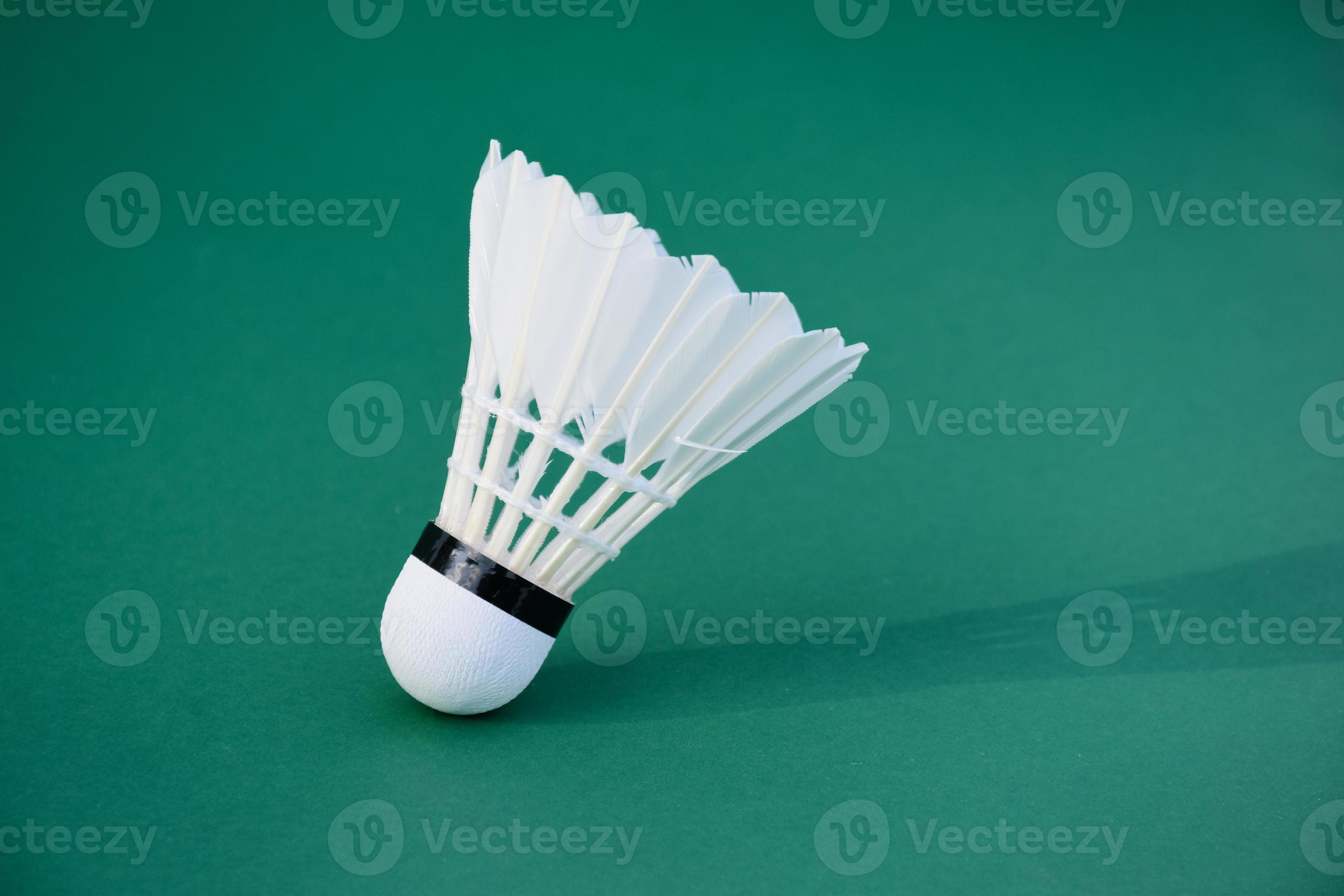Cream white badminton shuttlecock and racket on floor in indoor