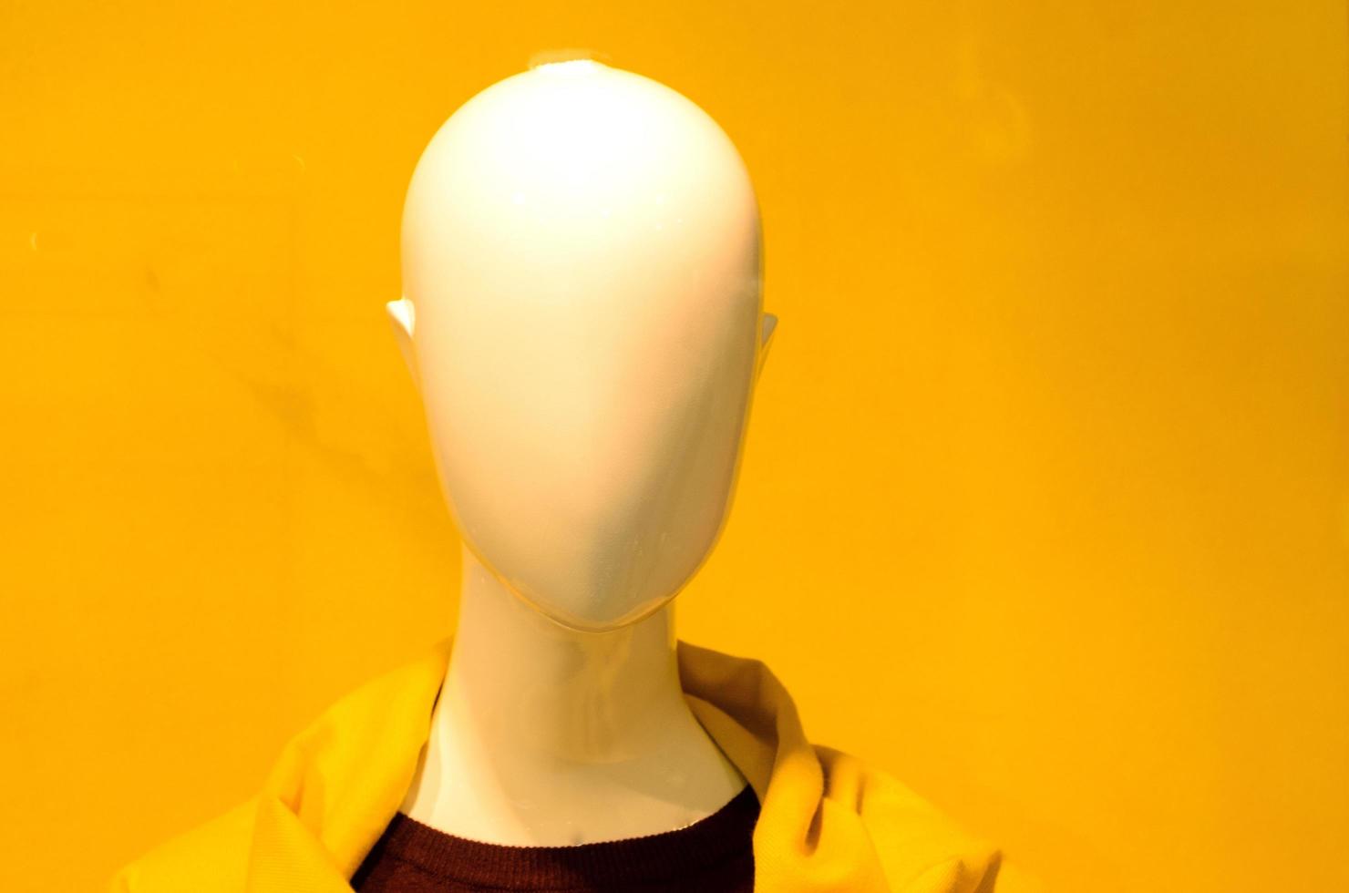 a mannequin head in a yellow jacket on a yellow background photo