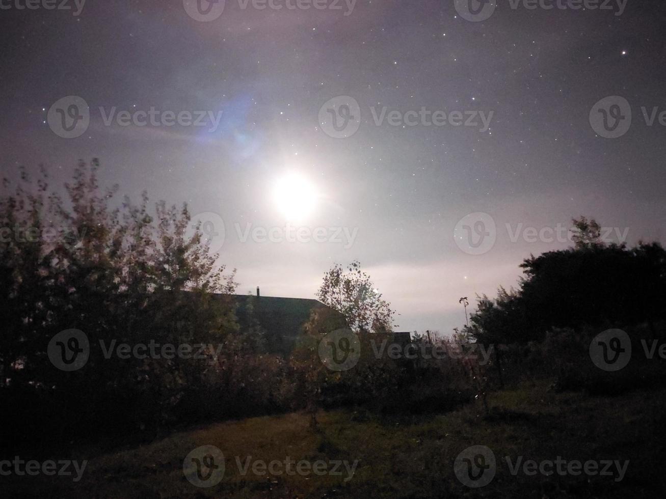 Bright night starry sky in the village photo