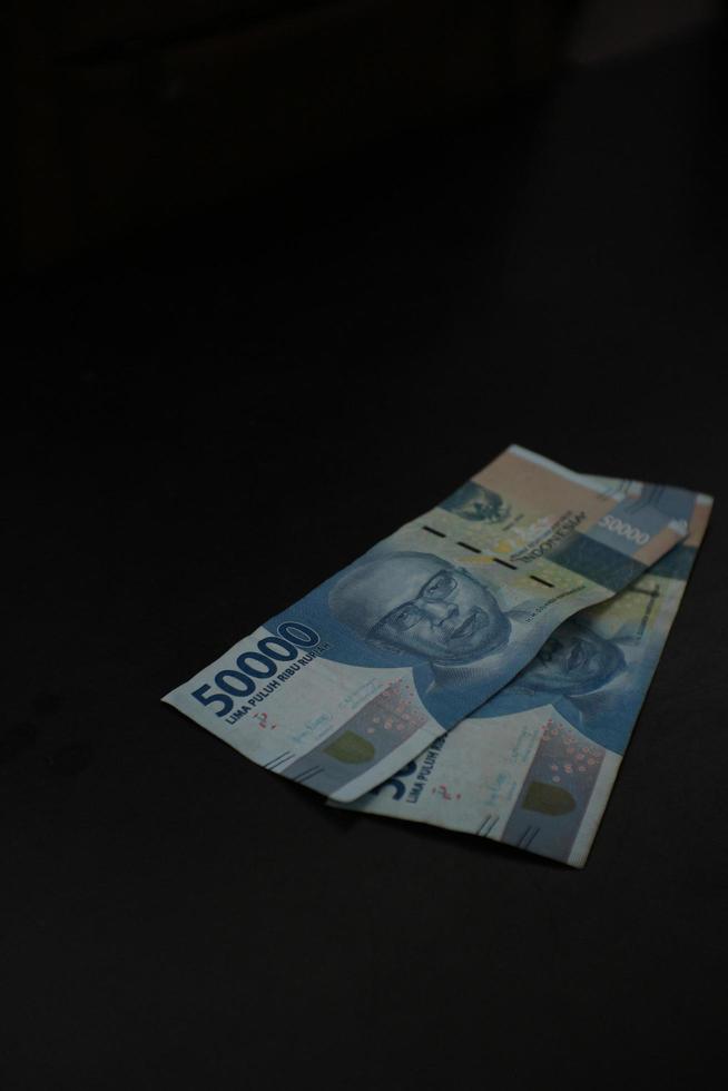 magelang,indonesia,2022 billetes de rupias indonesias en cincuenta mil denominaciones aisladas sobre fondo negro. foto