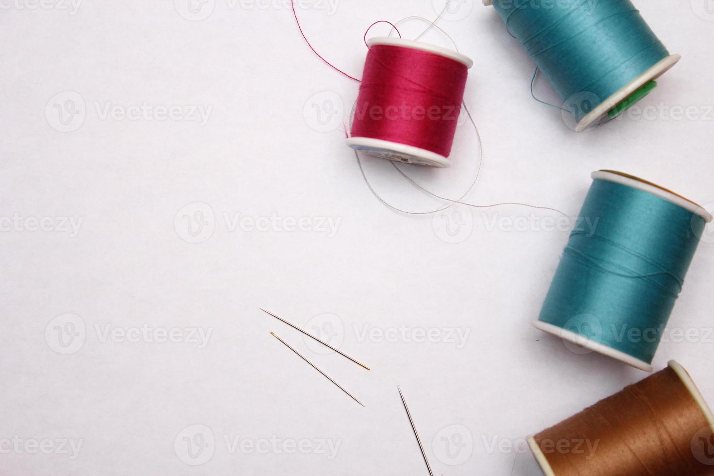 Multi-colored threads and old scissors spread out on a white floor, retro scissors, flat lay, copy space. photo