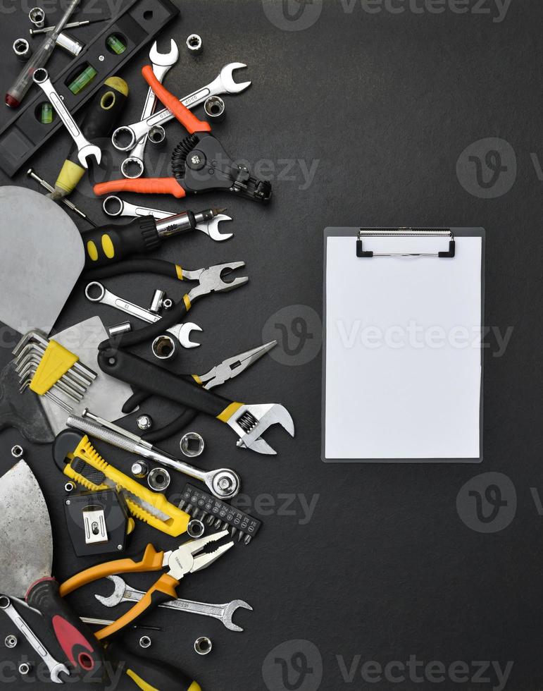 Handyman tool kit on black wooden table. Many wrenches and screwdrivers, pilers and other tools for any types of repair or construction works. Repairman tools photo
