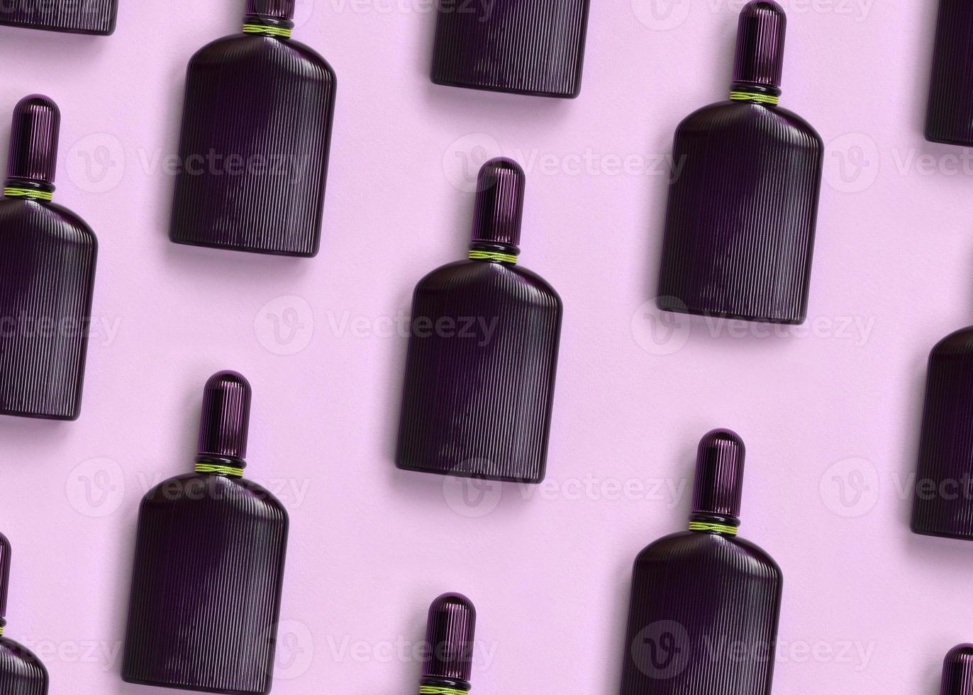 Dark purple perfume bottle with golden ribbon on pastel paper