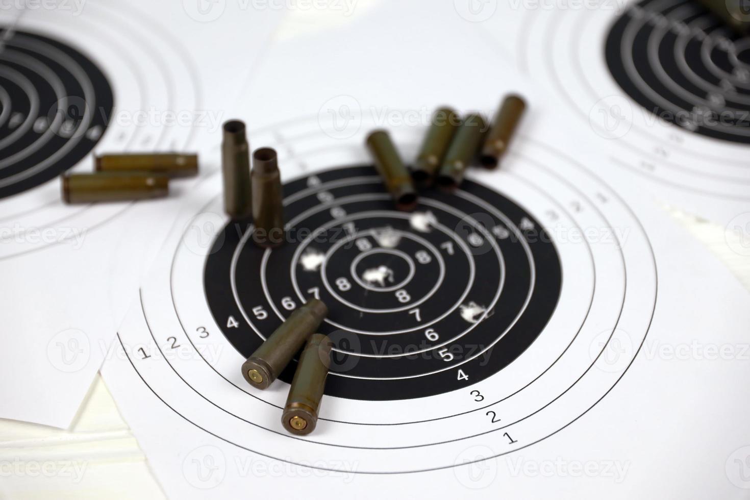 Many bullets on shooting targets on white table in shooting range polygon. Training for aiming and shooting photo